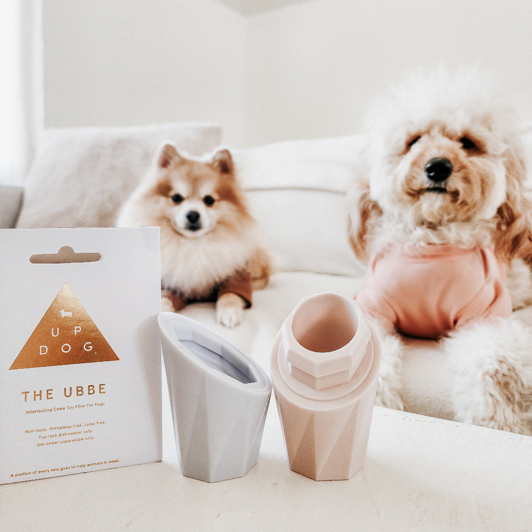 Two dogs sitting on a couch with the Ubbe Lite Licking Toy